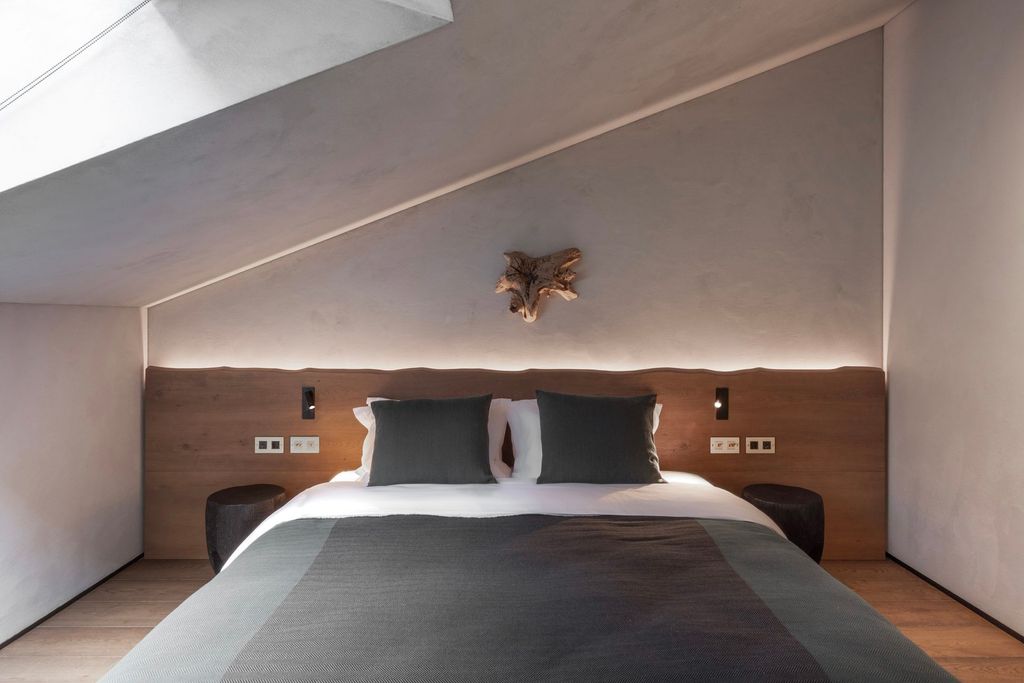 Loft room retreat with forest outlook, king-size bed, and natural, grounding style.