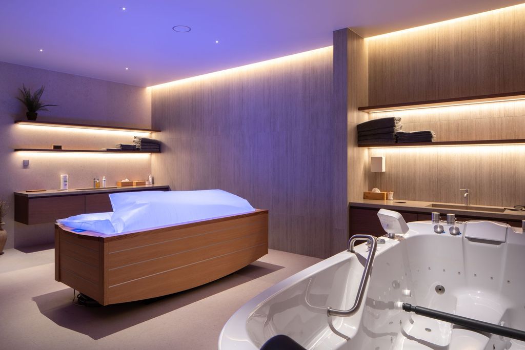Elegant spa treatment room with minimalist design and a comfortable massage bed.