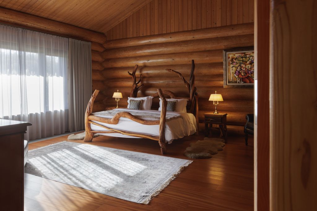 Light-filled bedroom with wood decorations in lakefront private villa.
